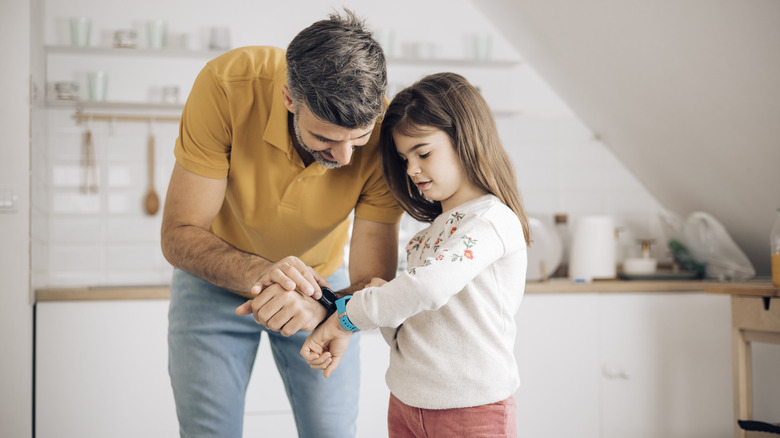 man and daughter using apple watch