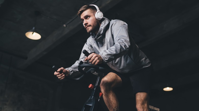 user riding a stationary bike with headphones on