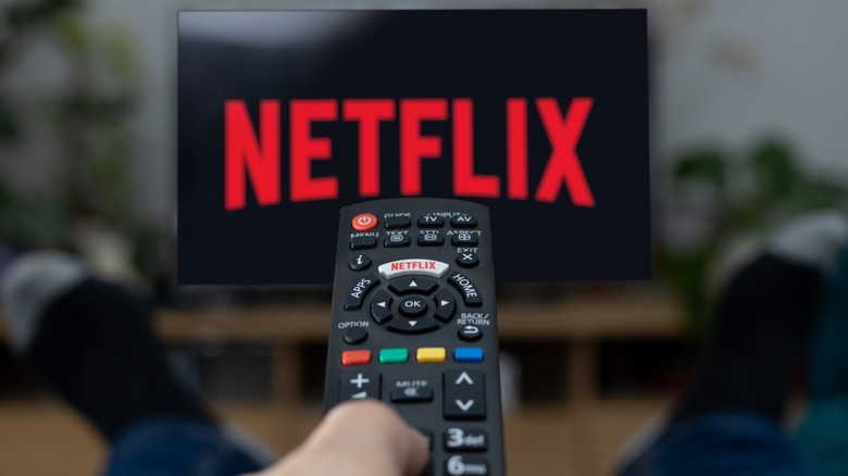 Remote control being pointed at TV with Netflix