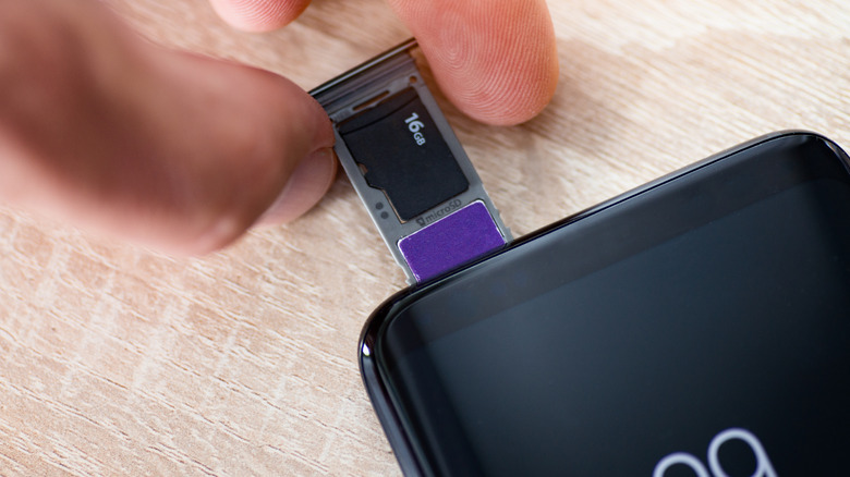 Person inserting MicroSD card into phone